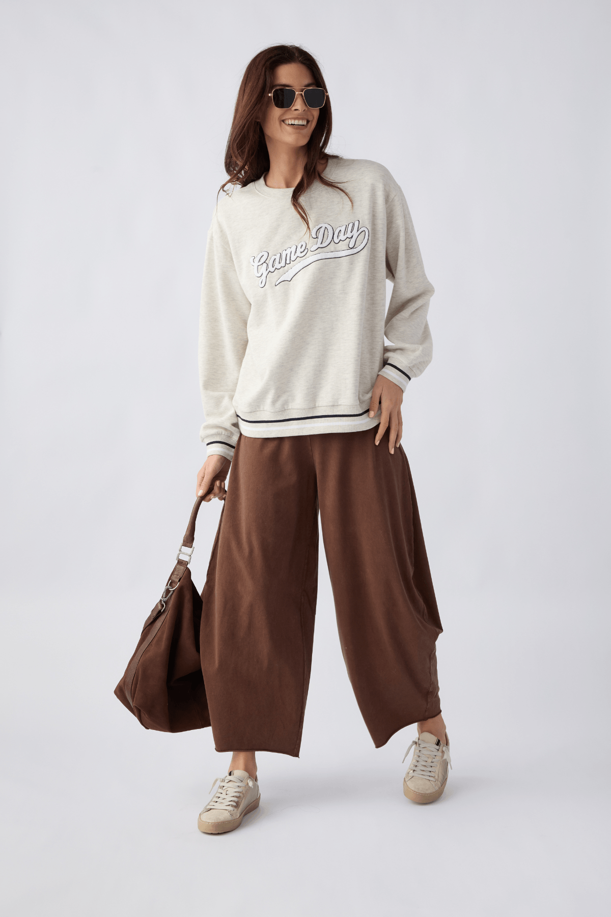 Light gray crewneck sweatshirt with 'Game Day' script graphic and striped cuffs
