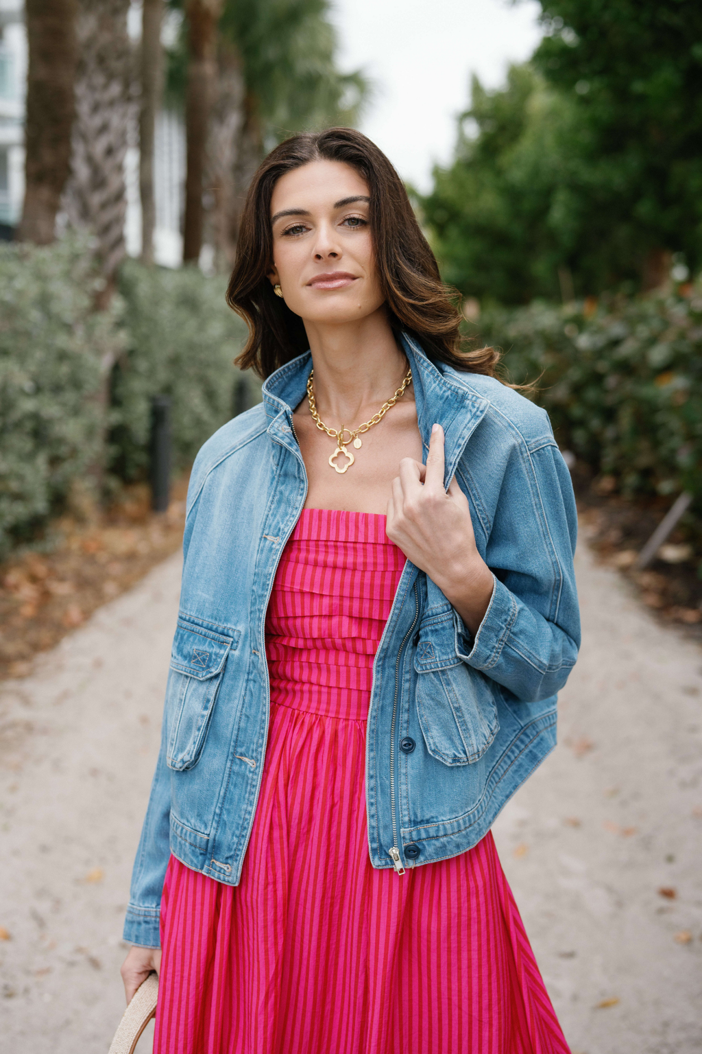 Gold clover pendant necklace on fine chain, worn at the collarbone.