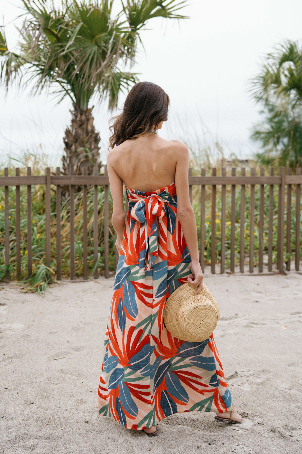 Back view of strapless palm print maxi dress with gathered center back