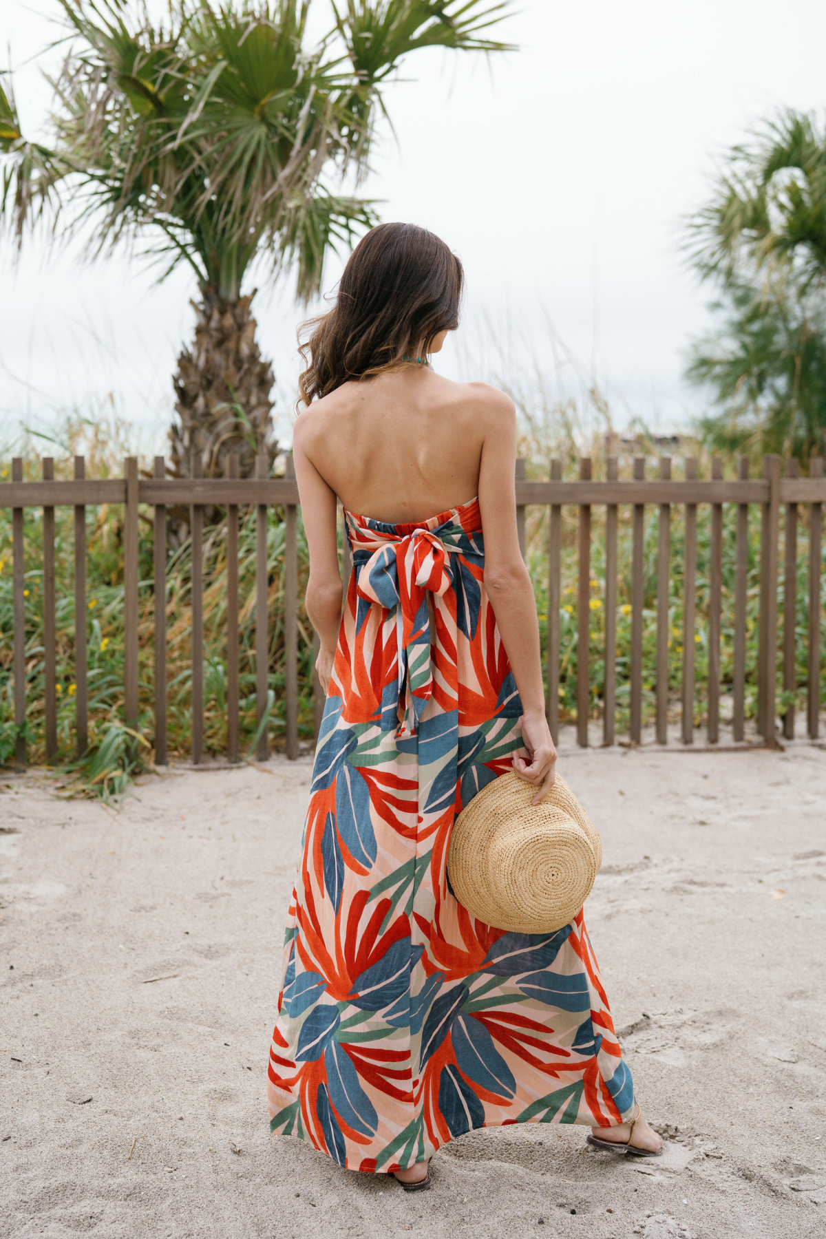 Back view of strapless palm print maxi dress with gathered center back