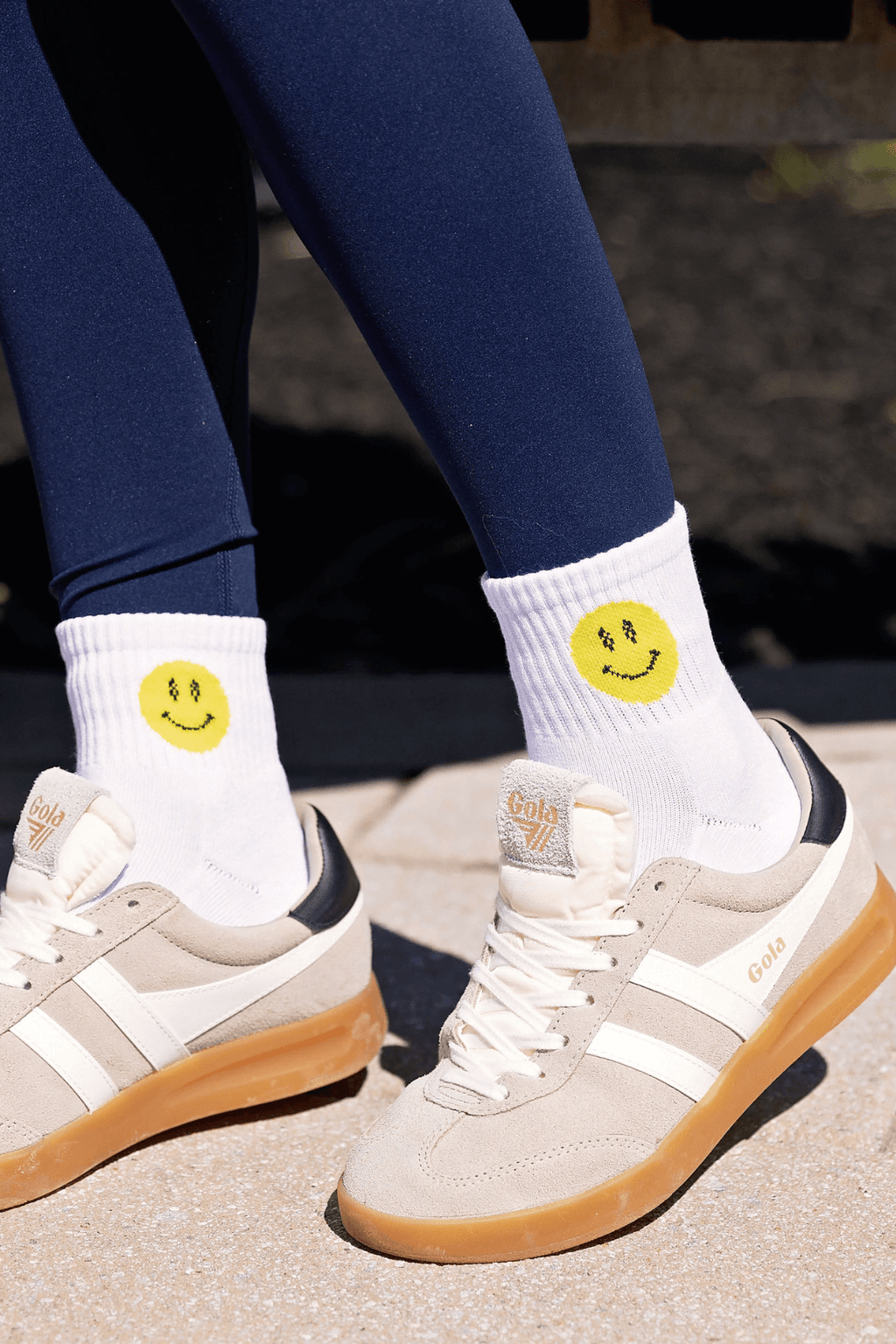 White ankle socks with yellow smiley face graphic on the cuff