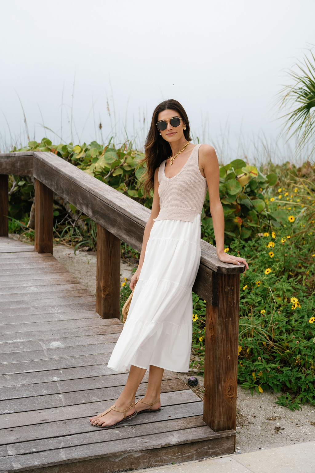 White sleeveless maxi dress with scoop neck and flowing tiered skirt