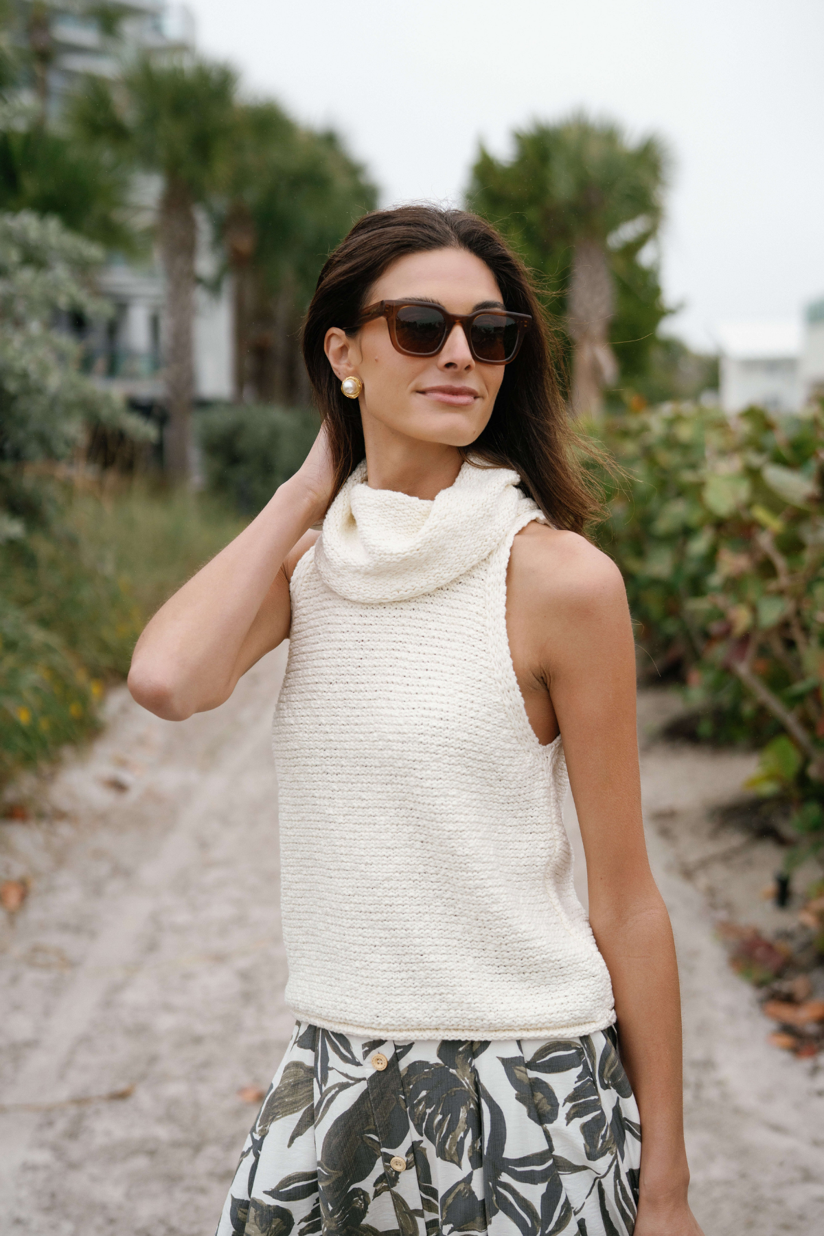 Ivory sleeveless textured knit top with high cowl neckline, angled view