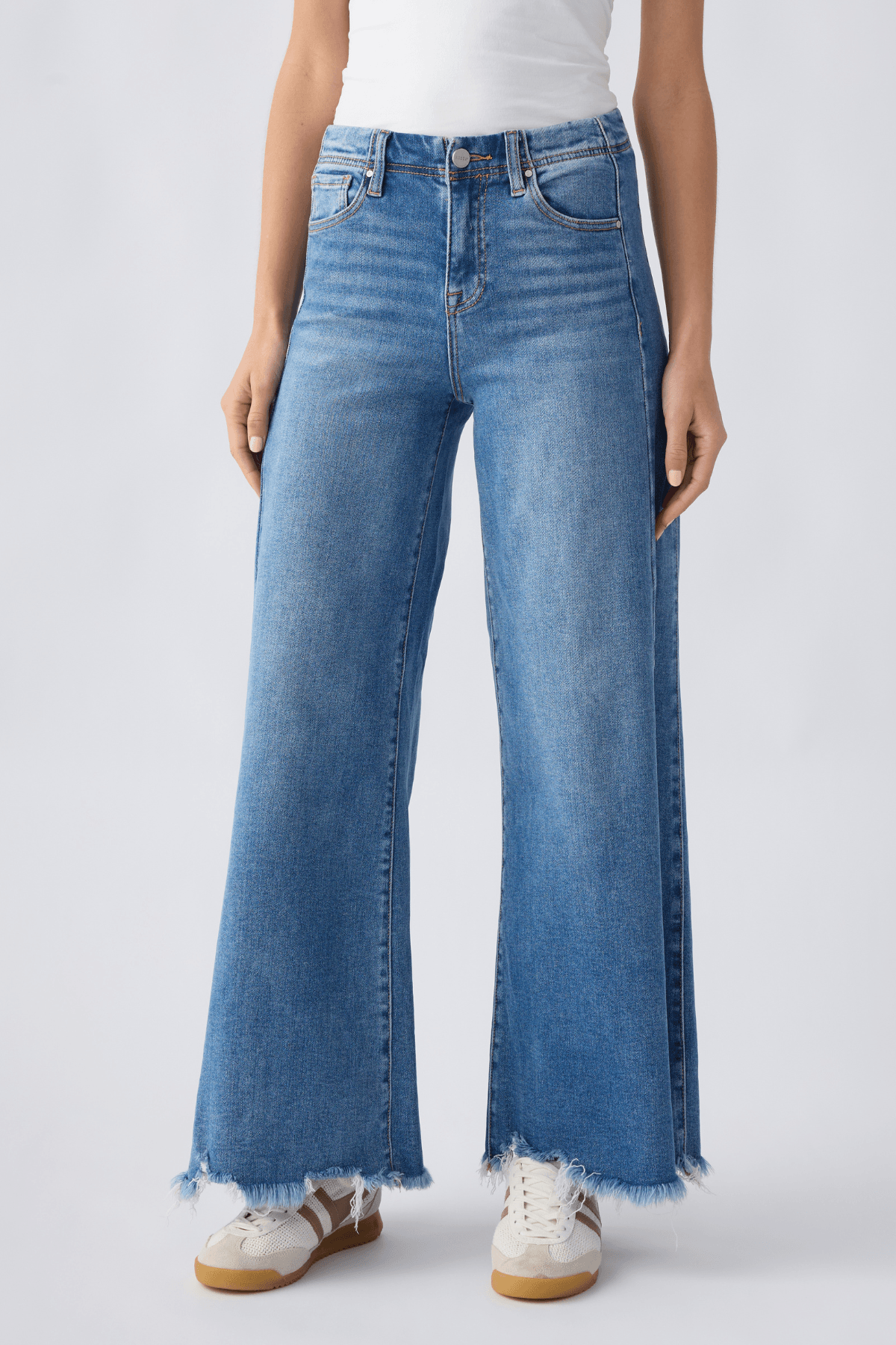 Front view of medium wash high-rise ultra wide leg jeans with five pockets and frayed cuffs.