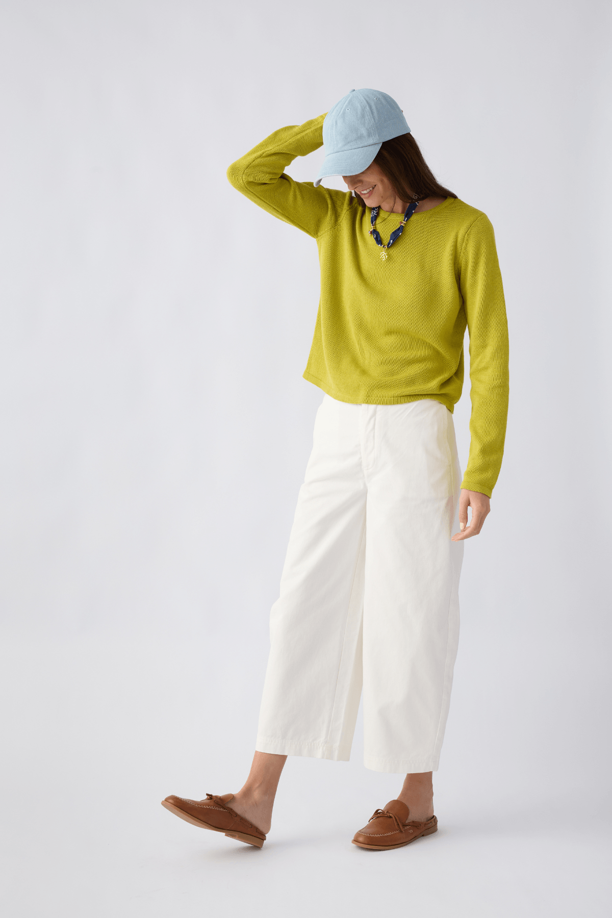 White/ivory chino pants with front button closure, belt loops, and cropped tapered hem