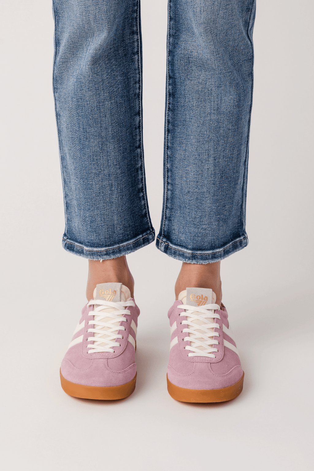 Pink lace-up low-top sneakers with white stripes and gum rubber sole