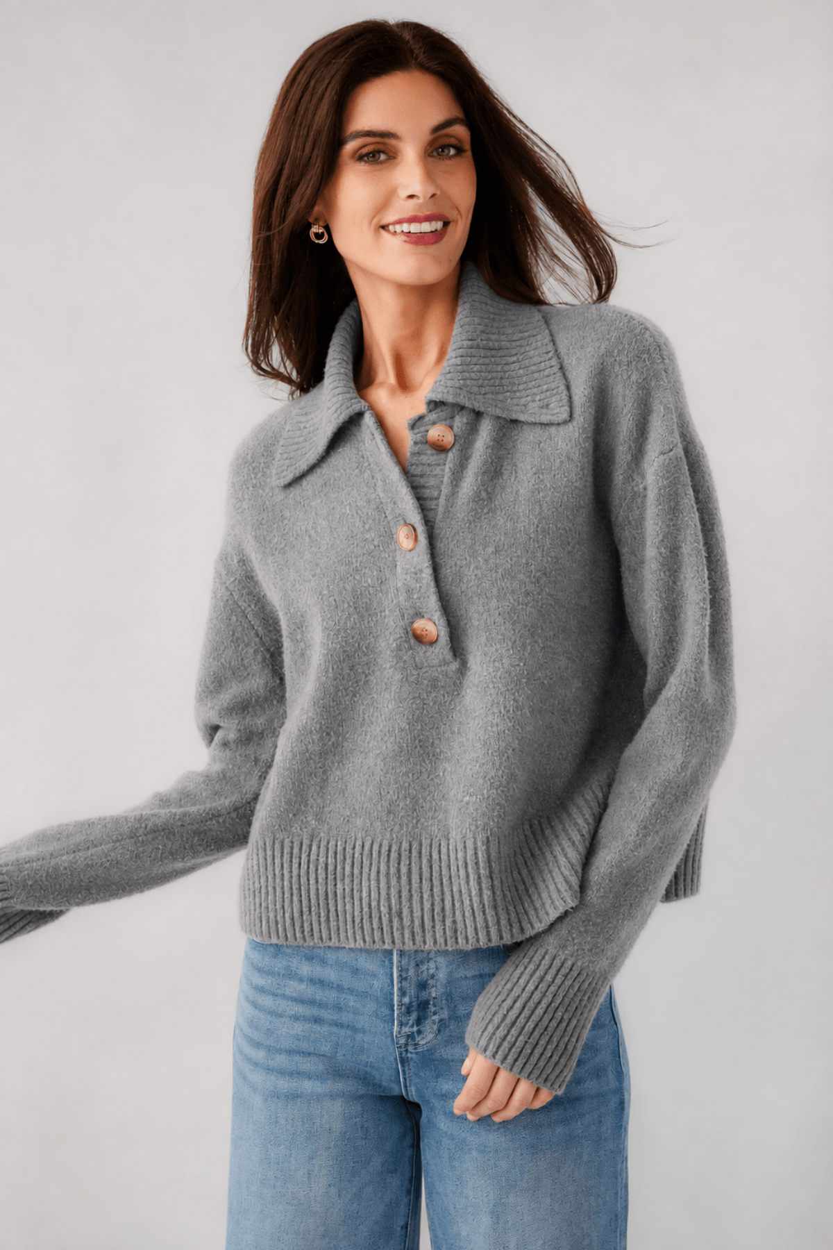 Grey knit polo sweater close-up, turn-down collar with buttons, long sleeves, ribbed hem