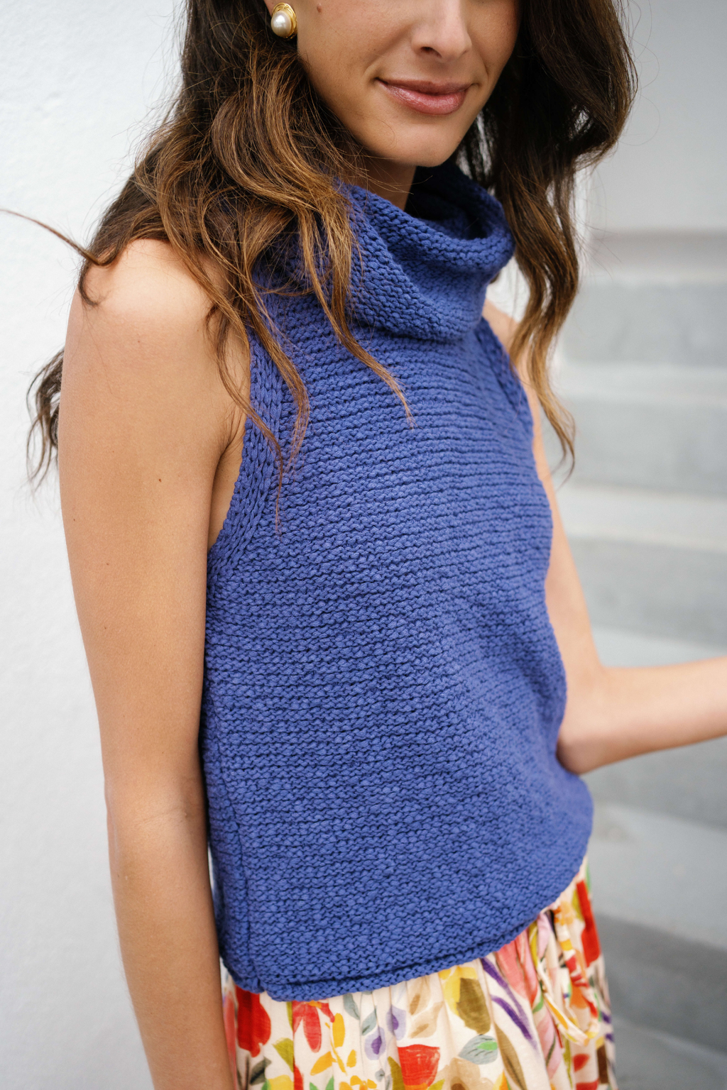 Blue sleeveless knit cowl-neck top, close-up of textured knit and cowl collar.