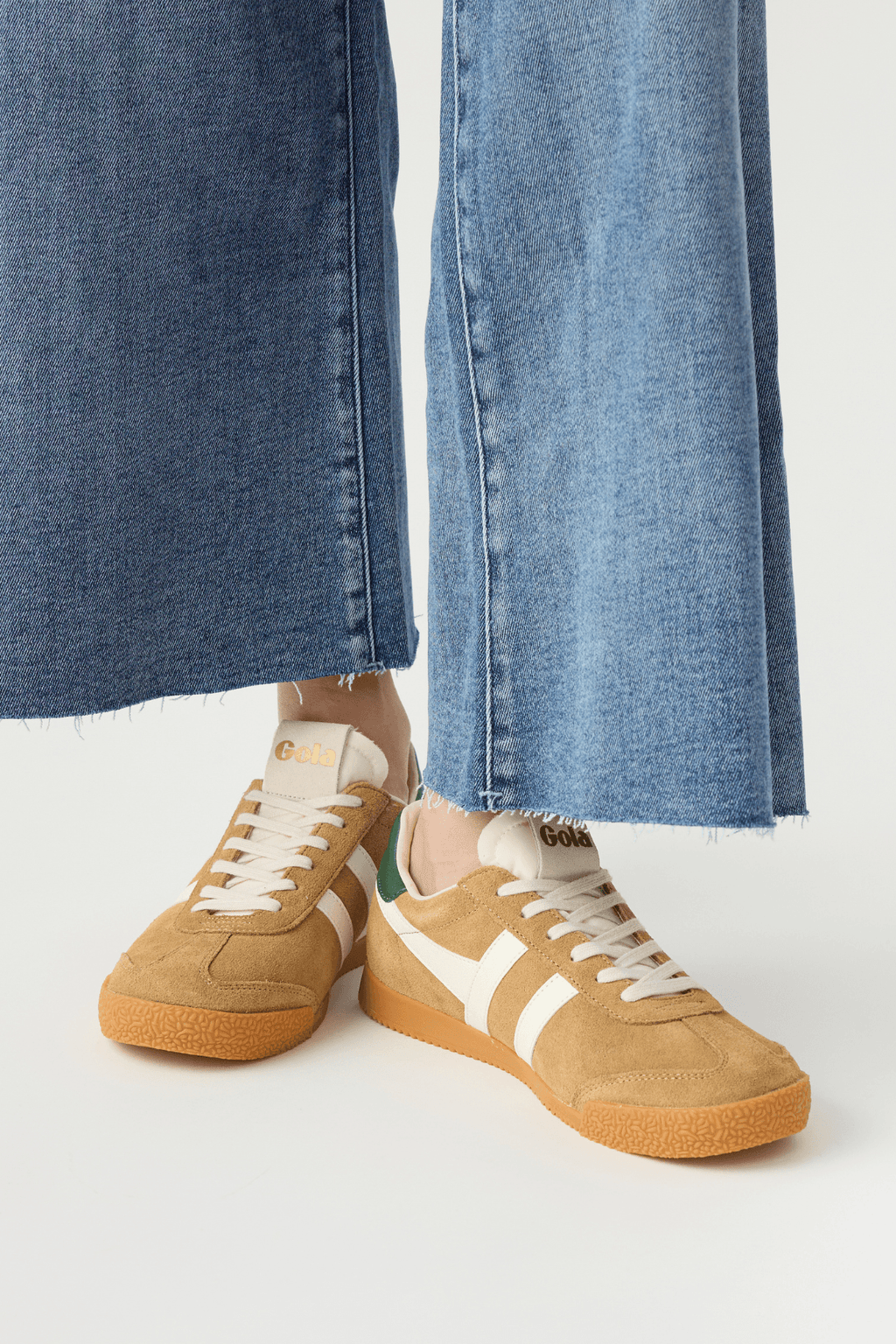 Elan sneakers front side view, tan suede with off-white stripes, green heel details, gum sole.