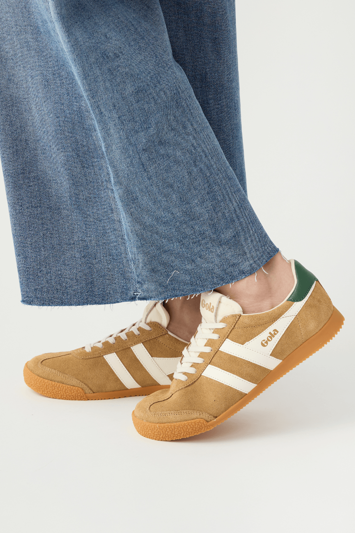 Elan sneakers with tan suede upper, off-white three stripes, green tongue patch, laces.