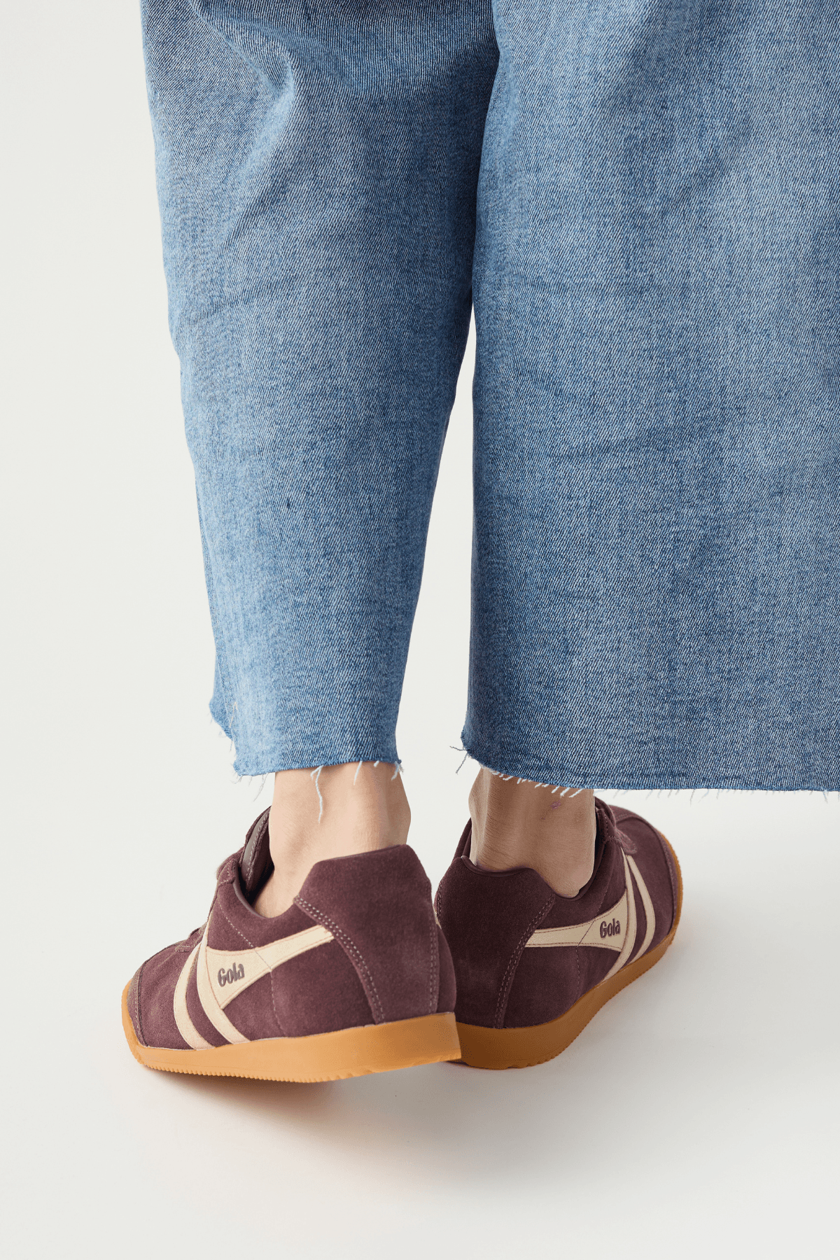 Cocoa brown lace-up sneakers with white stripes, visible heel, and gum sole