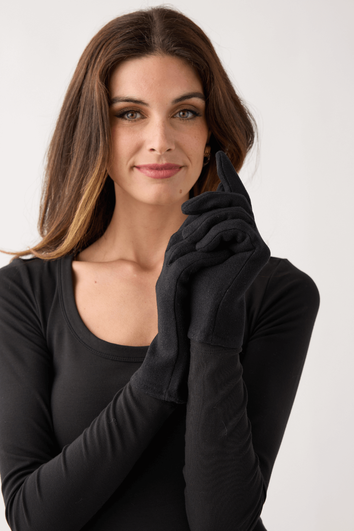 Black plain knit gloves with soft wrist cuff, hands crossed near the neck.