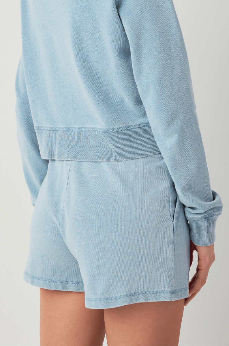 Women’s light blue knit denim shorts with overlapping front waistband seam detail