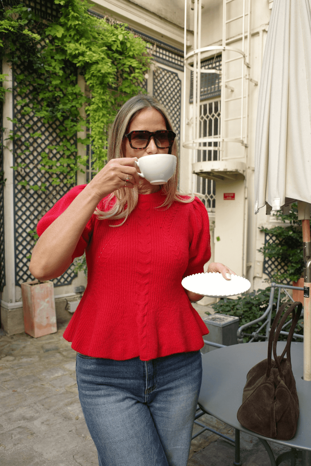 Red knit peplum top with puff sleeves and textured cable pattern, styled for outdoor wear.