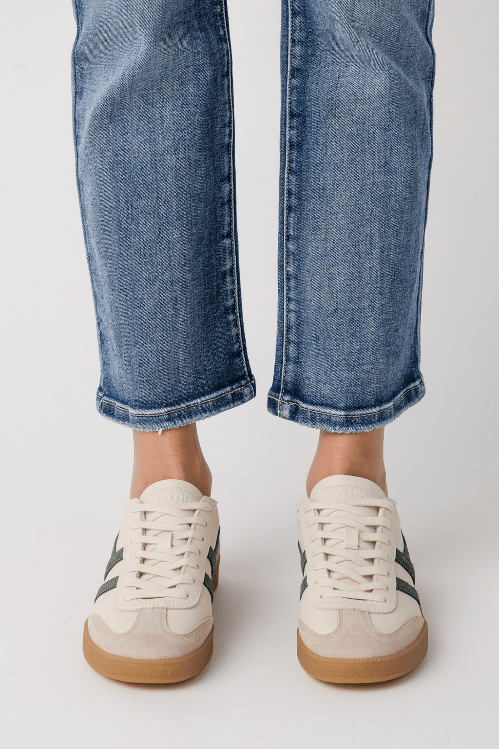 White leather sneakers with gum sole and subtle green accent at heel