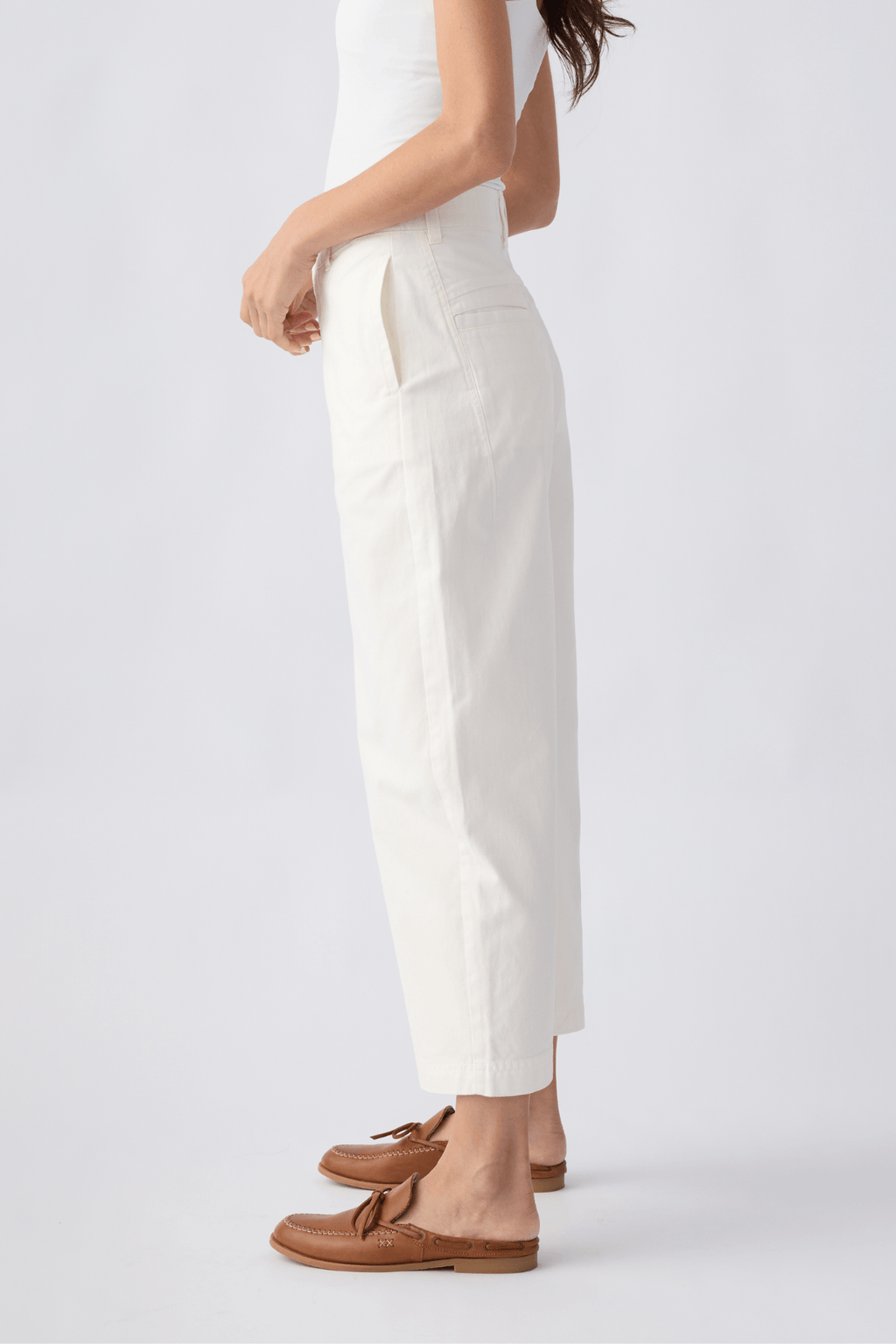 Ivory chino pants with side seams, belt loops, and straight cropped legs