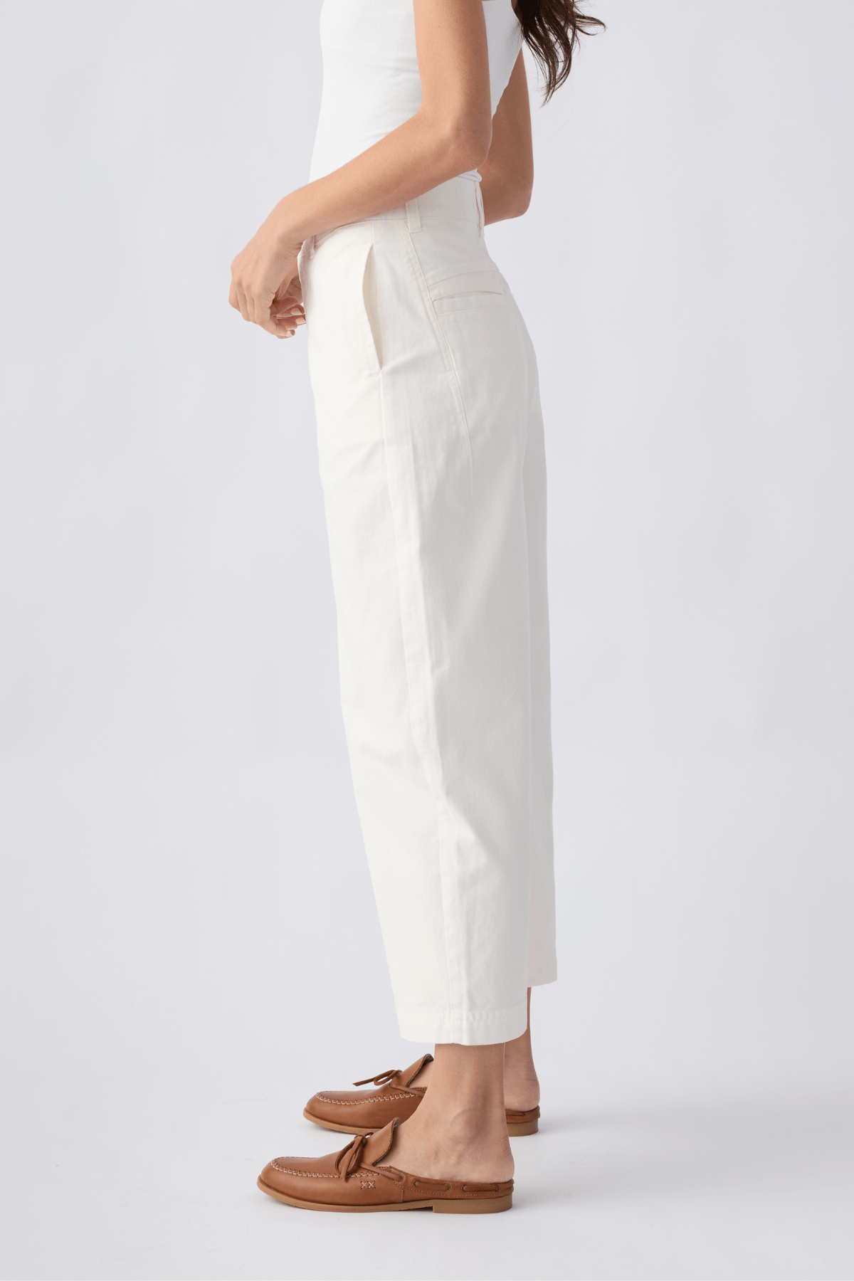 Ivory chino pants with side seams, belt loops, and straight cropped legs
