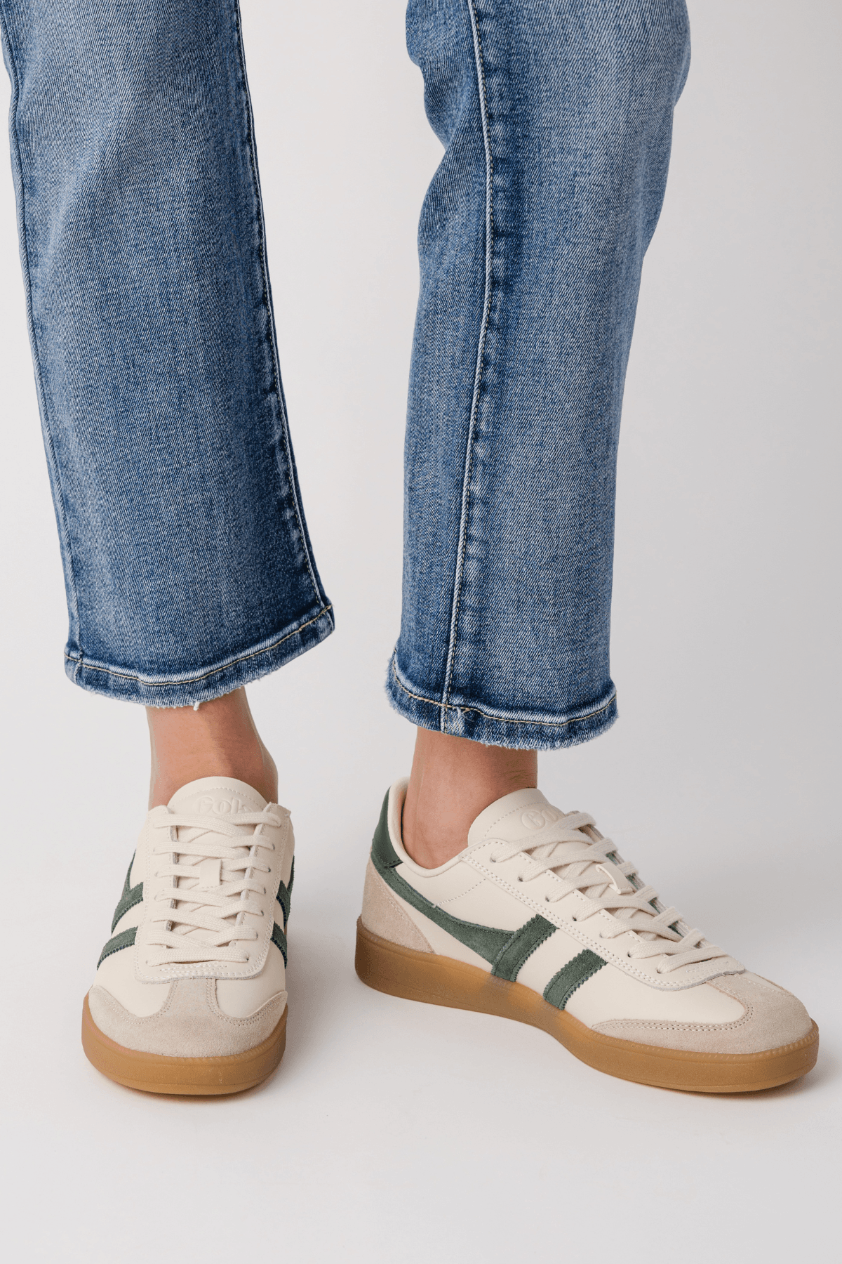 White leather sneakers with green stripes and gum outsole