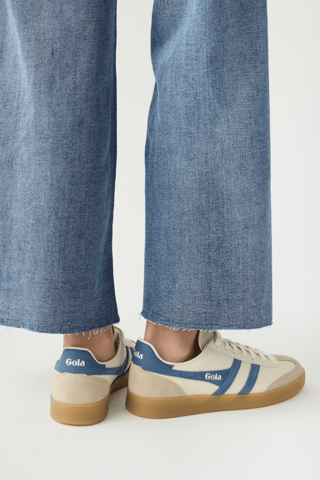 White leather sneakers with blue heel tab, Gola logo, and gum outsole