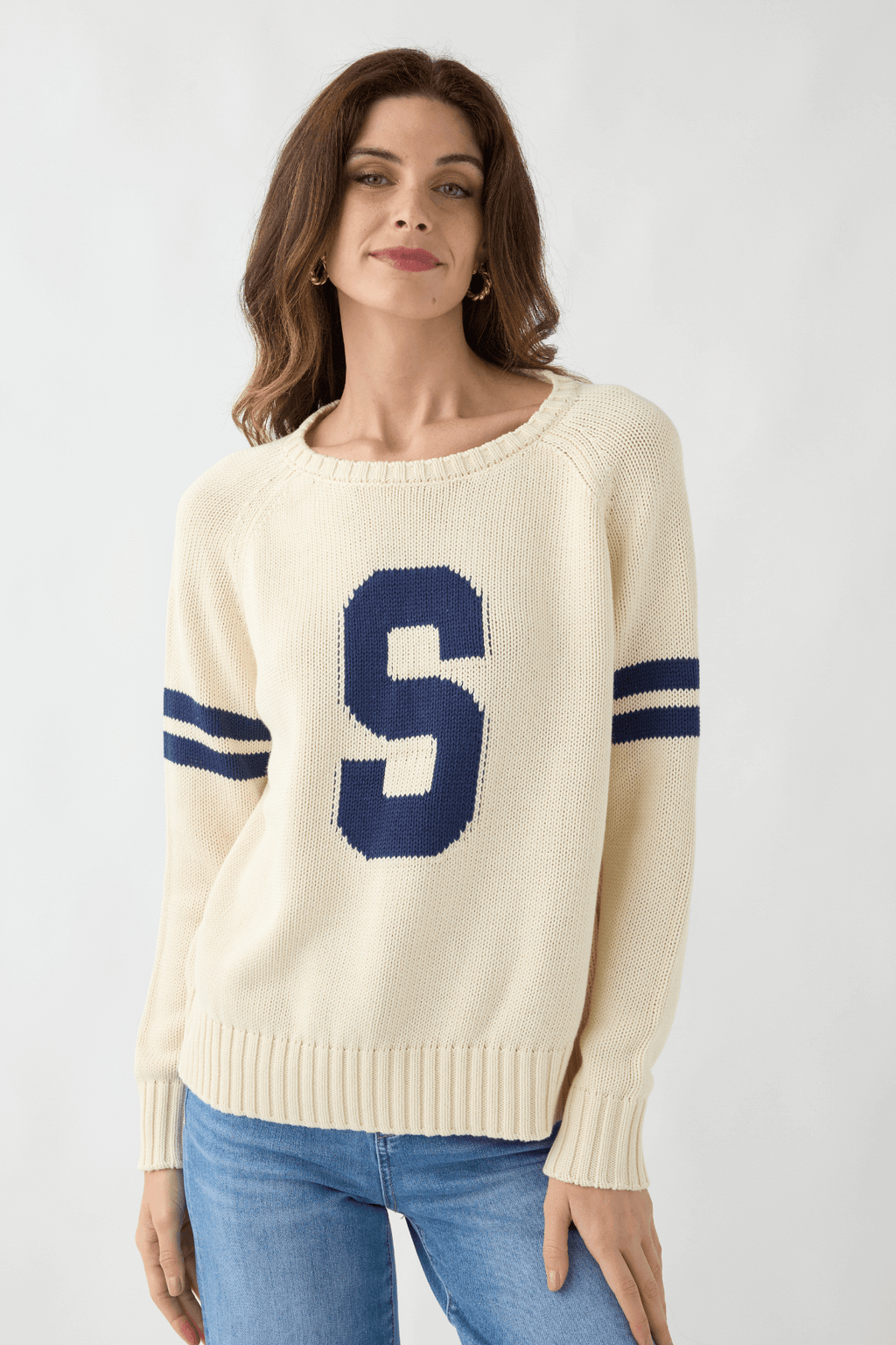 Cream knit sweater with large blue "5" patch and striped ribbed cuffs