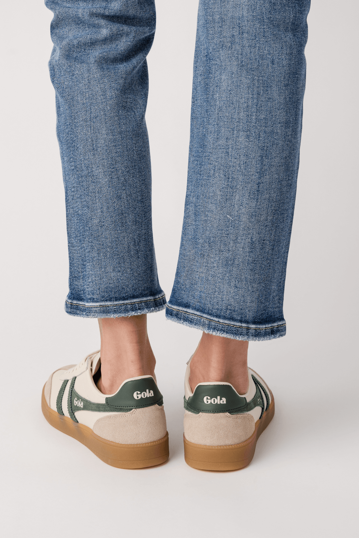 Back view of white leather Gola sneakers with green heel panel and gum sole
