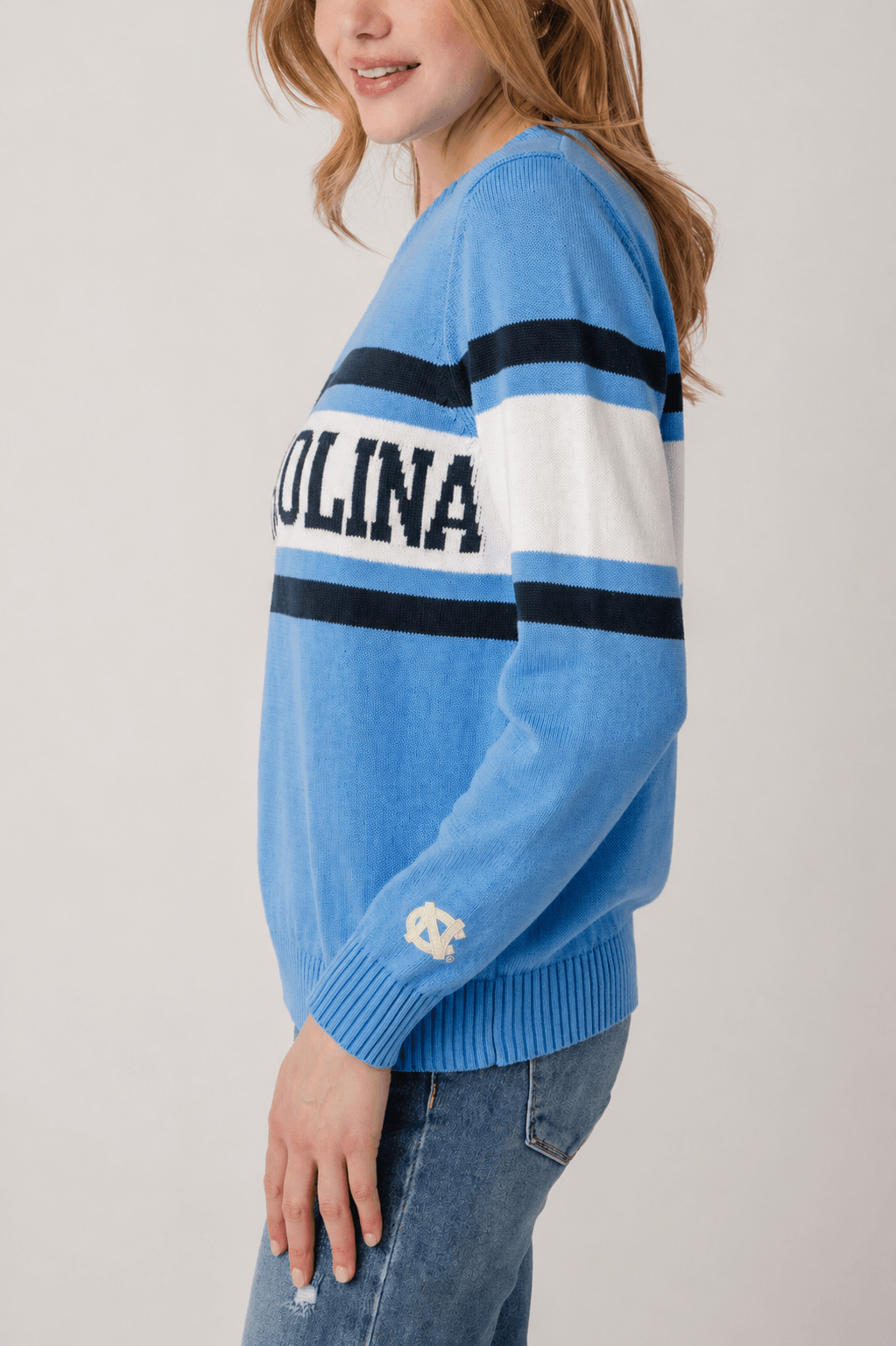 Vintage campus sweater in light blue with striped sleeve and small text graphic on cuff