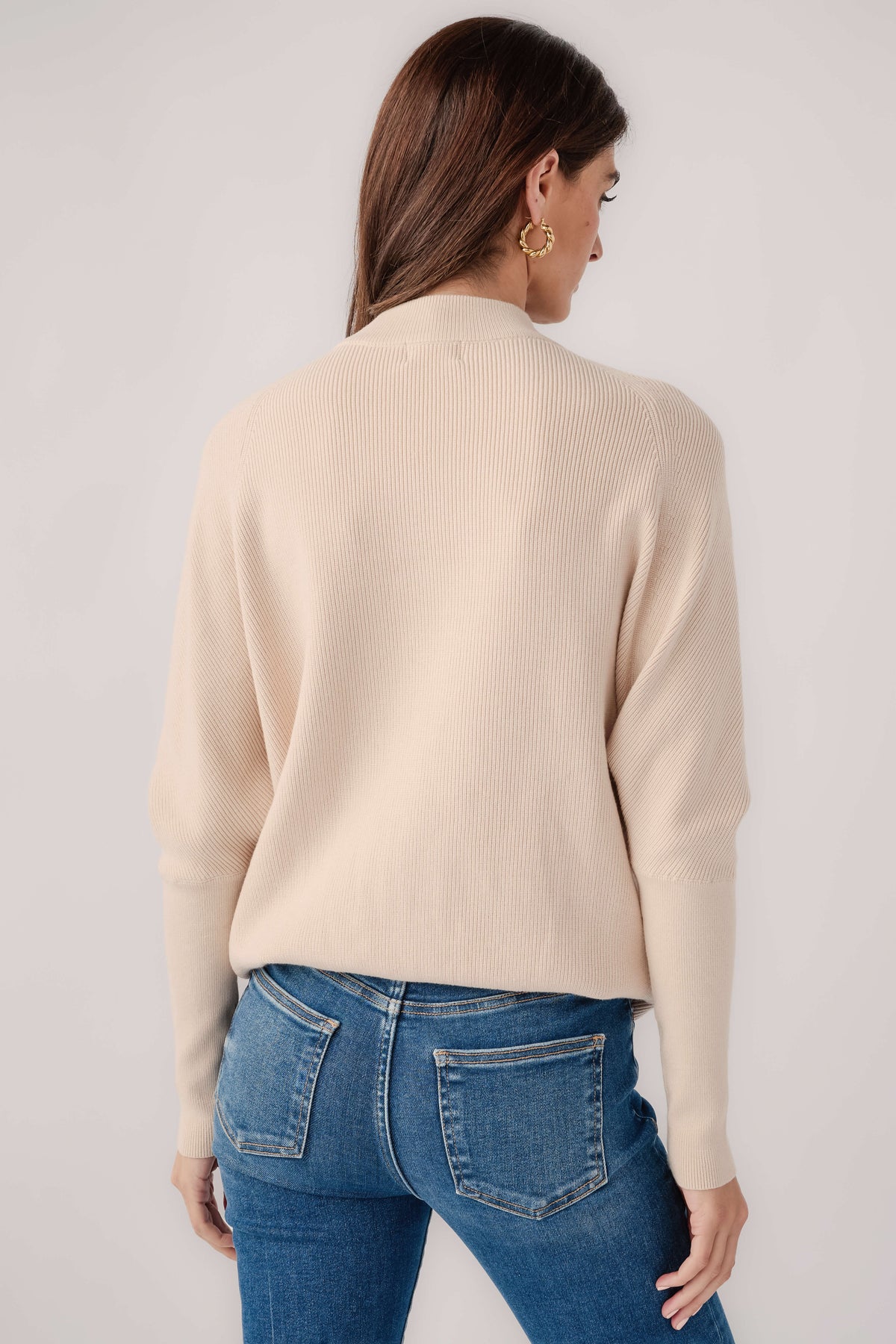 Cream slouch-neck dolman pullover sweater viewed from the back