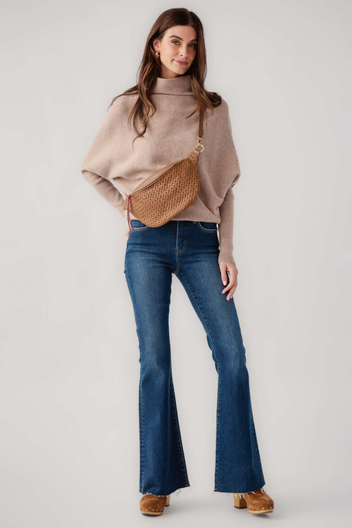 High-rise dark blue flare jeans with frayed hem and five-pocket design on model