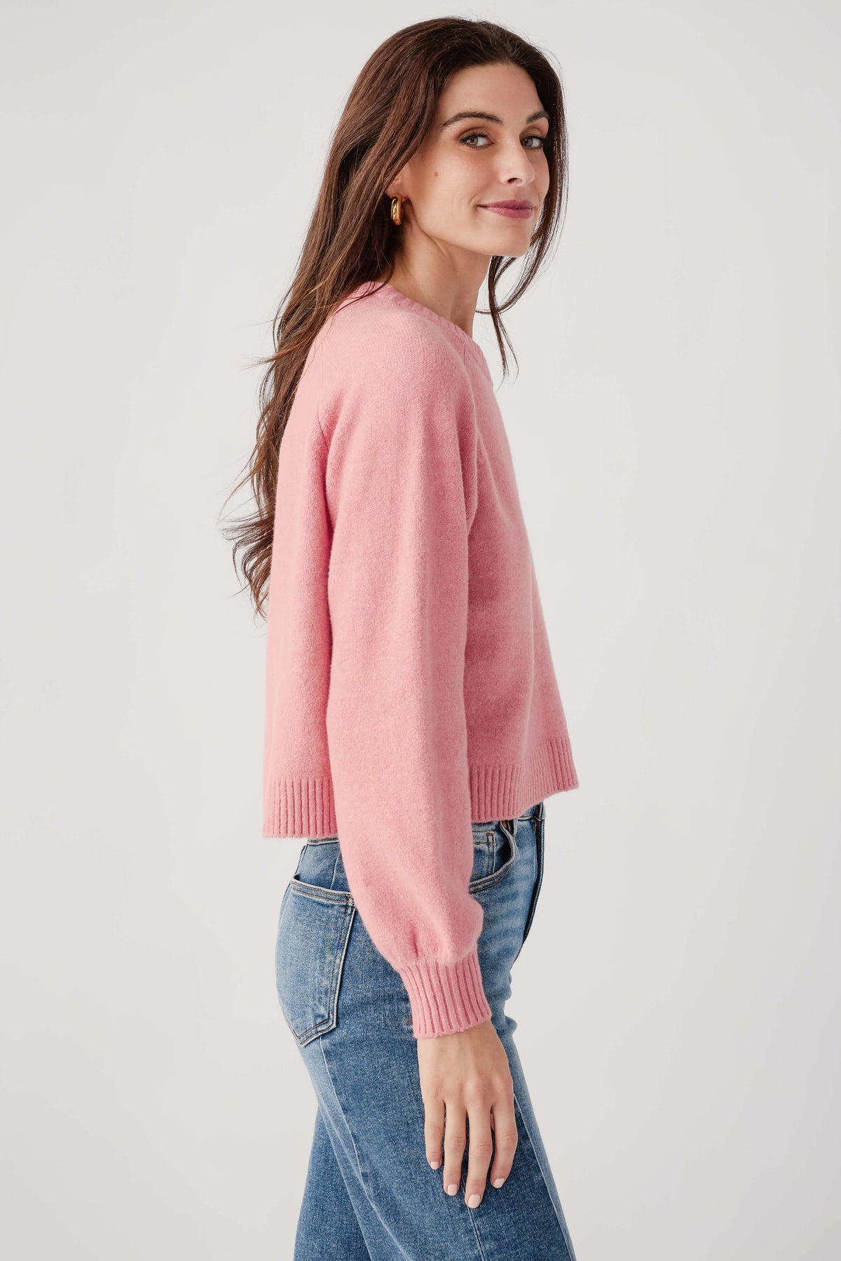 Pink crewneck knit sweater, side view with ribbed hem and cuffs