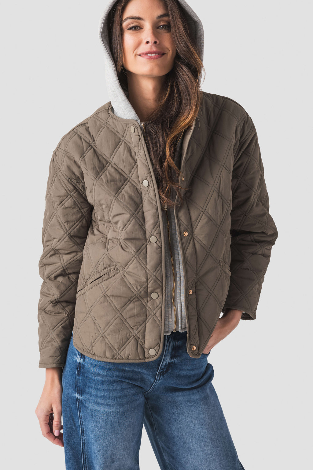 Olive quilted jacket hoodie with hood and snap pockets near hem