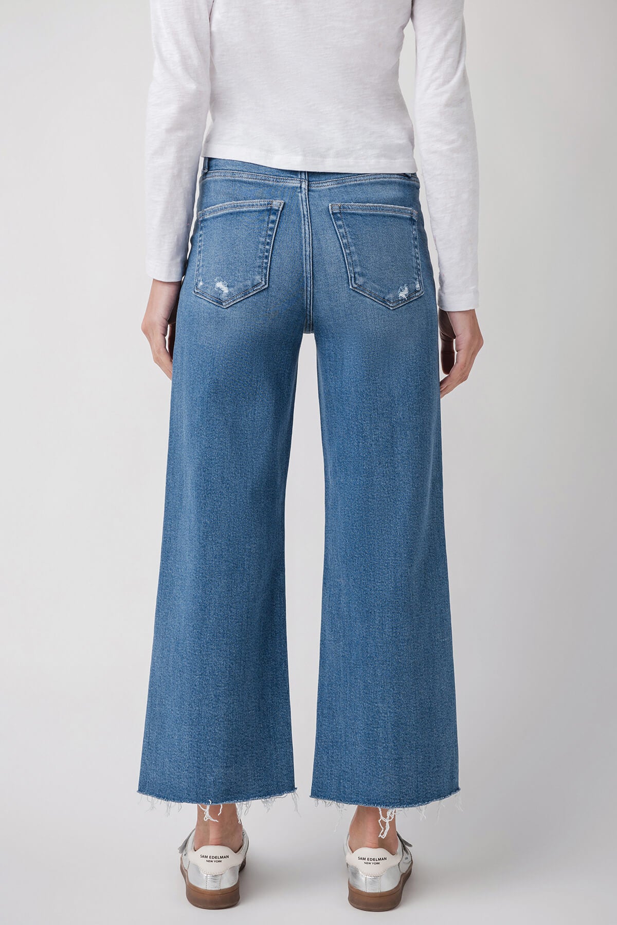 Medium wash ankle flare jeans with back pockets and wide straight-leg fit