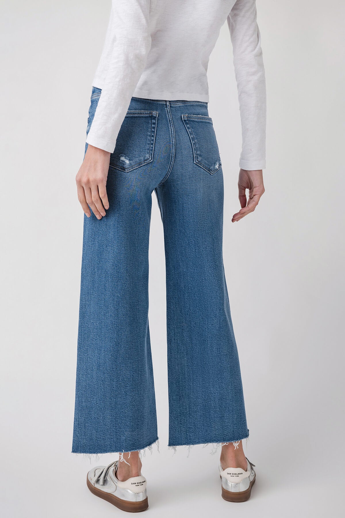Medium wash ankle flare jeans with belt loops and curved front yoke seams