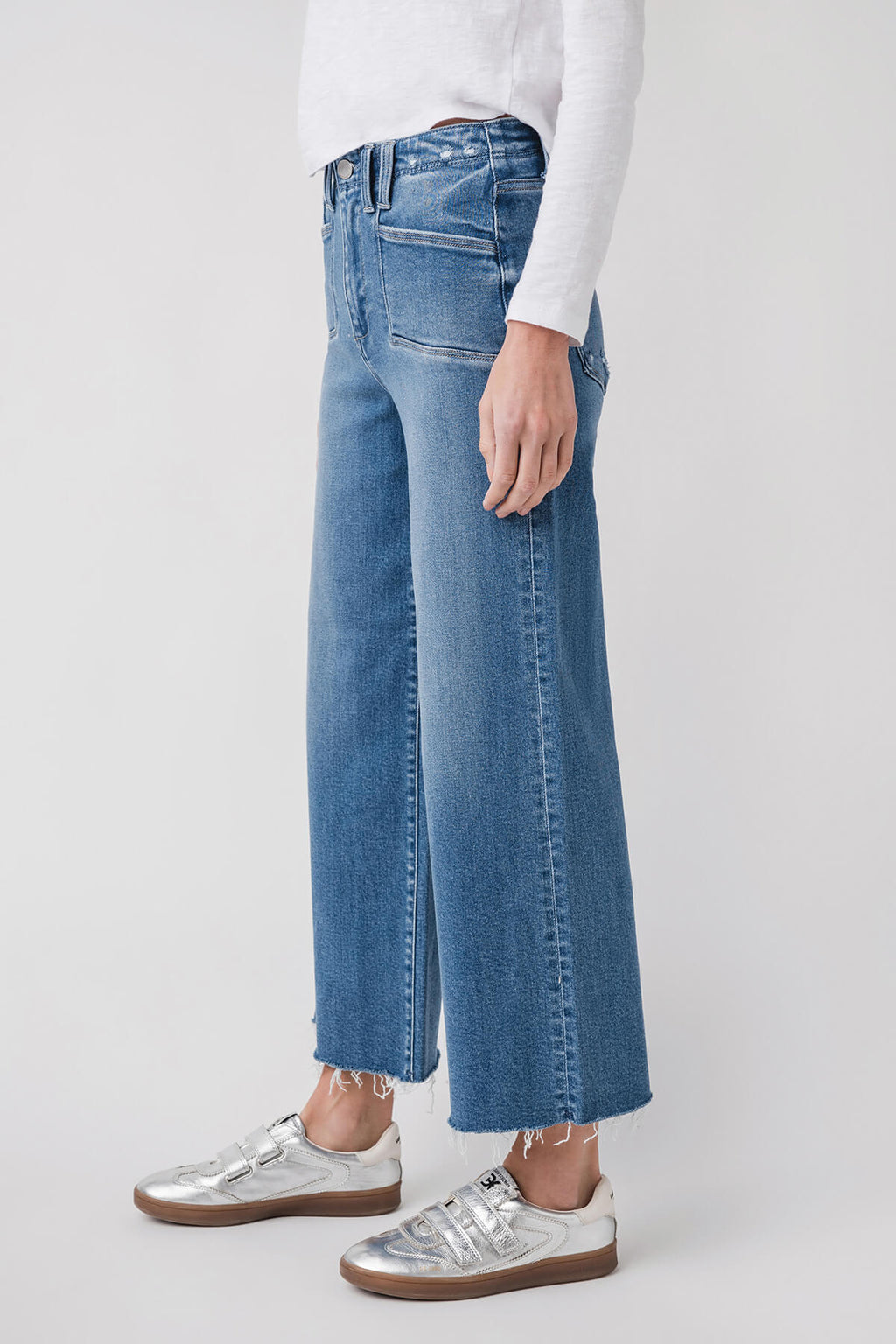 Medium wash ankle flare jeans with vertical seam details and frayed hem