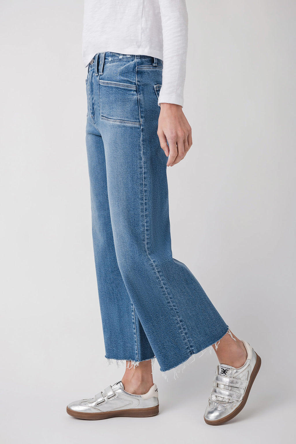 Medium wash ankle flare jeans showing side seam and wide bootcut shape