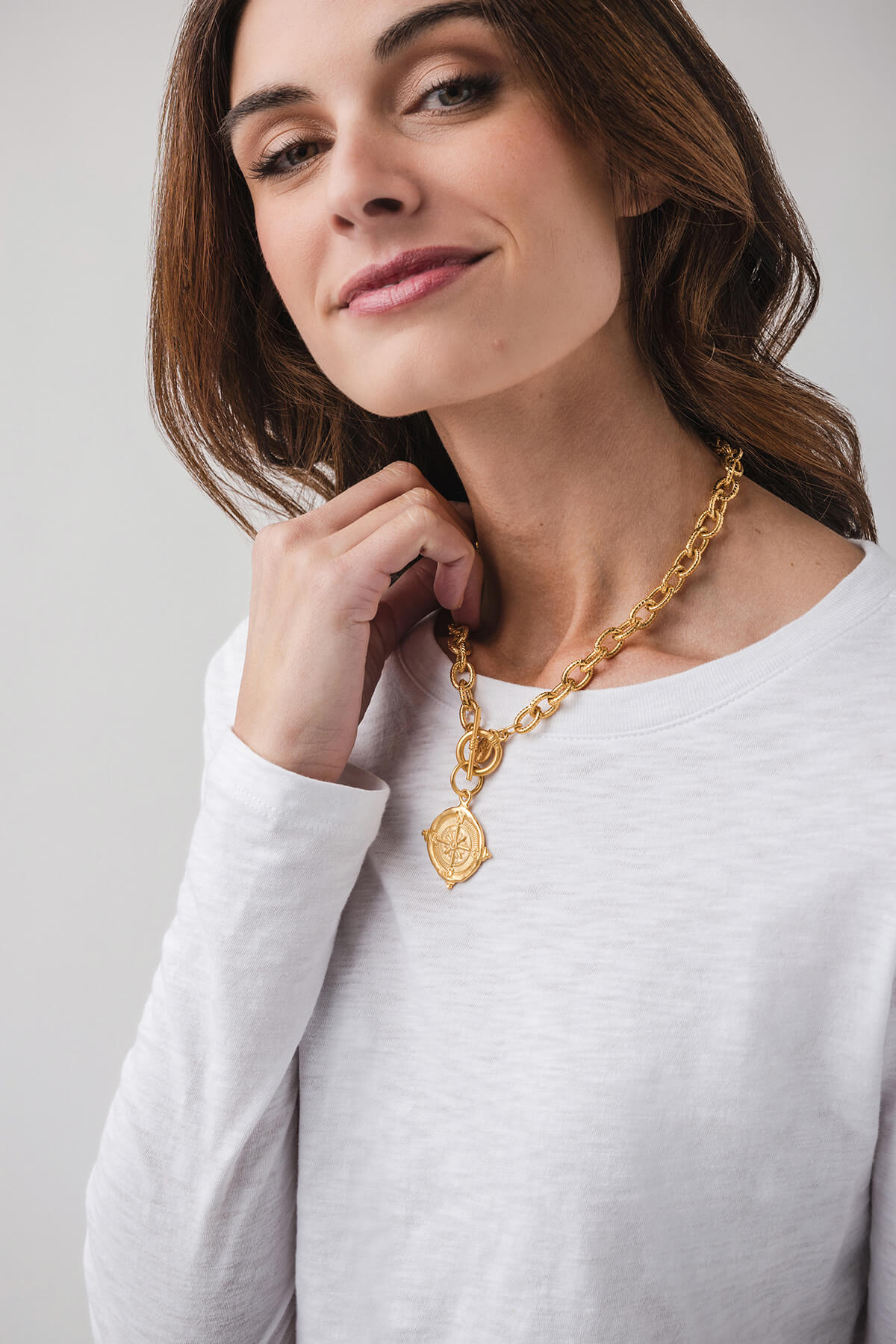 Gold curb chain necklace with compass pendant and circular toggle clasp