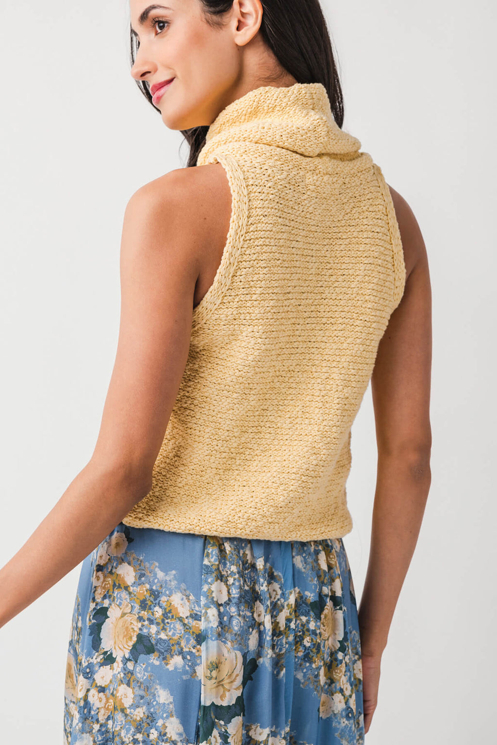 Warm yellow sleeveless knit top from back view with cowl neckline