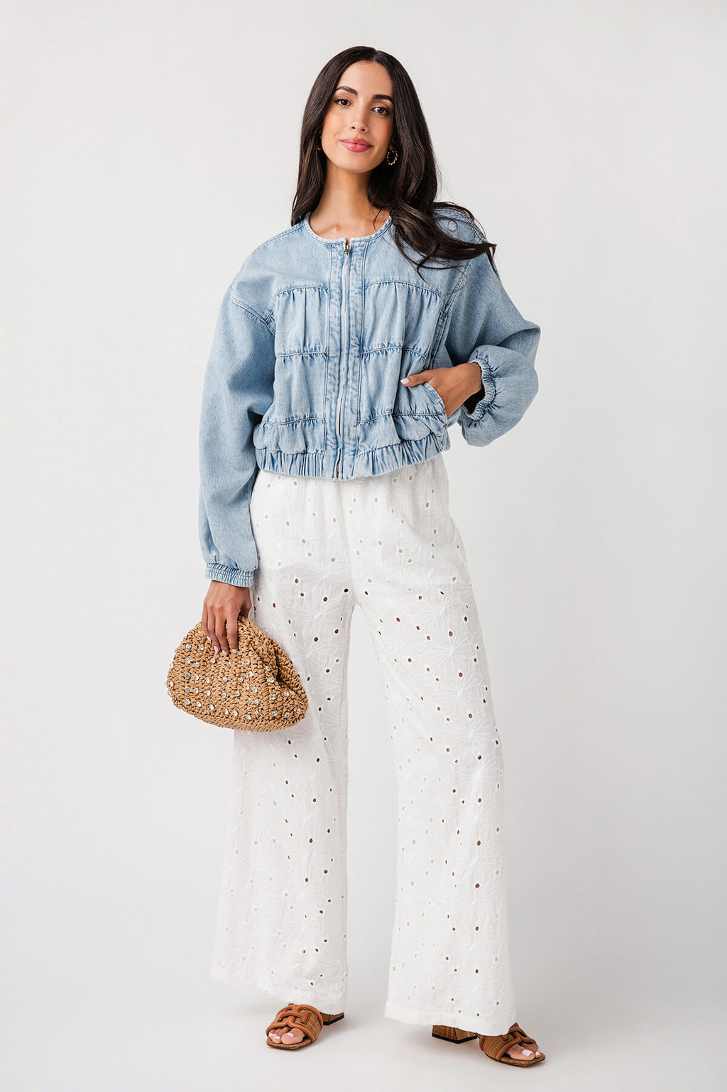 Beaded straw clutch worn as crossbody, held at side