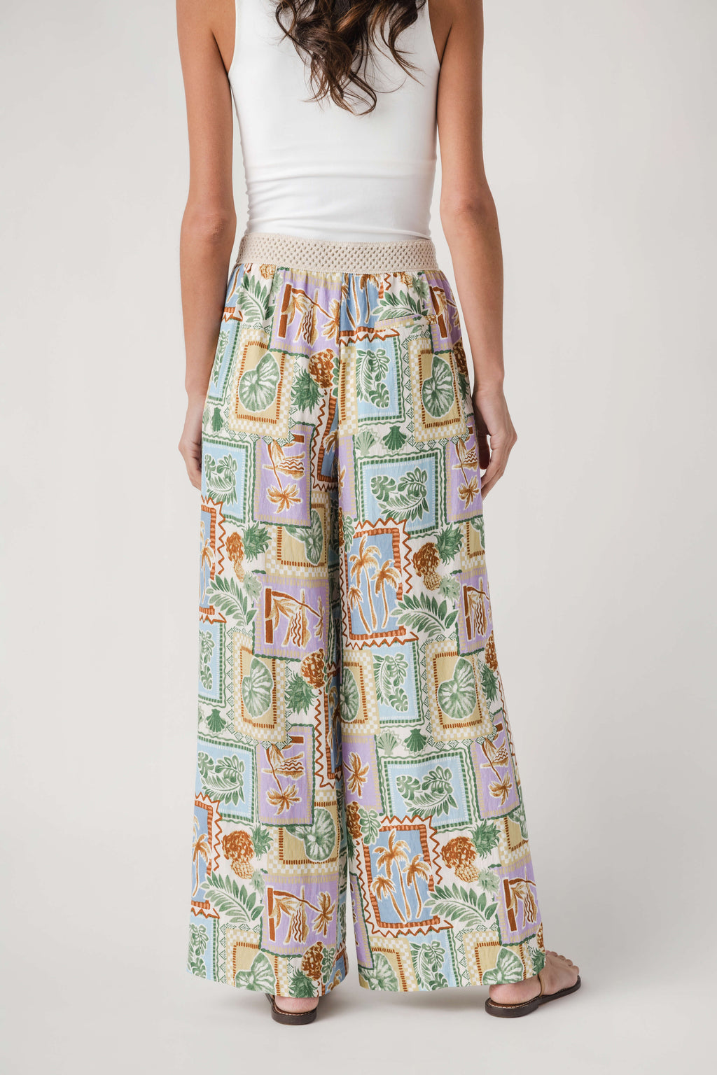 Wide-leg pants with colorful tropical patch print and elastic waist, back view