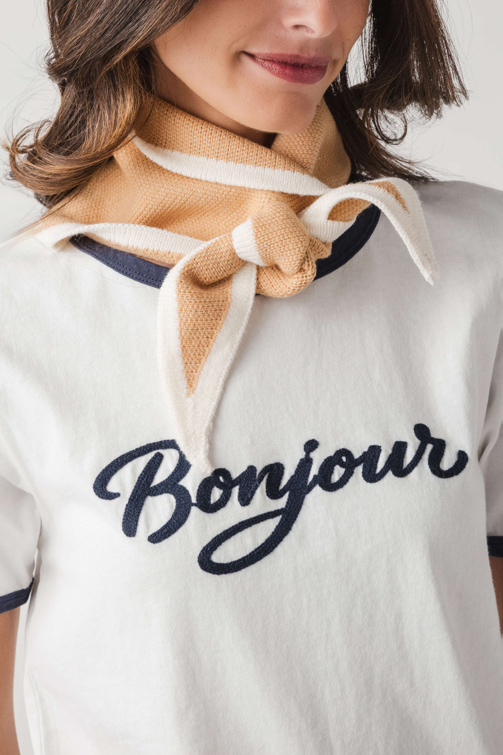 Khaki triangle knit scarf with striped knit ends, tied in a visible knot