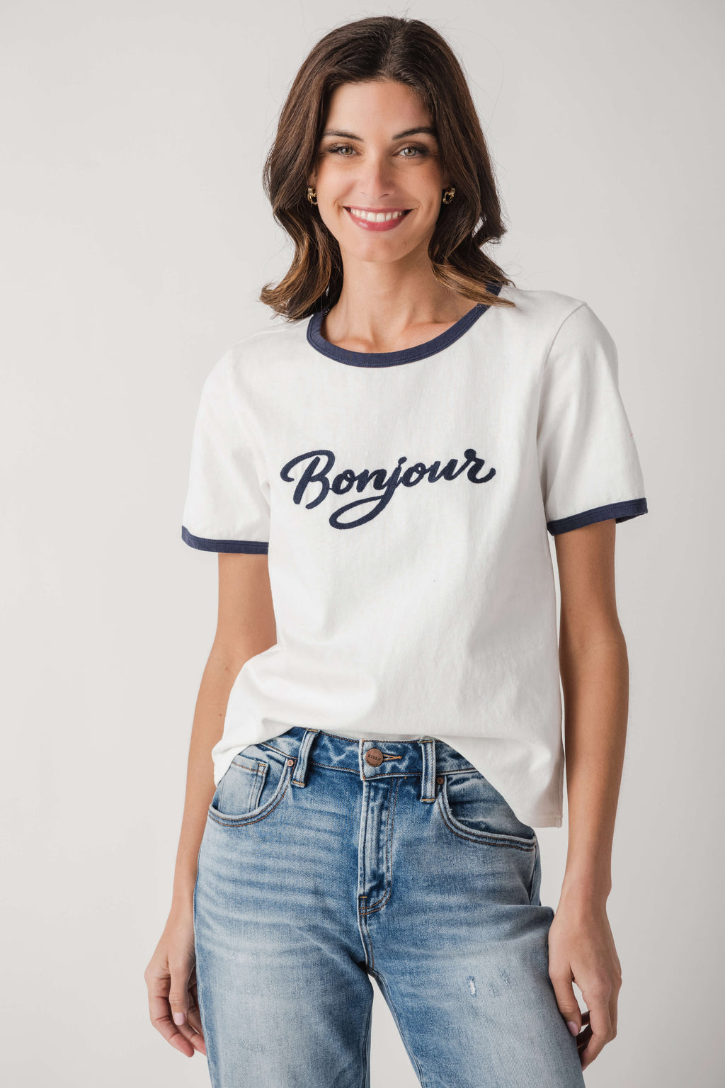 White Bonjour T-shirt with navy collar and sleeve trim, worn with blue jeans