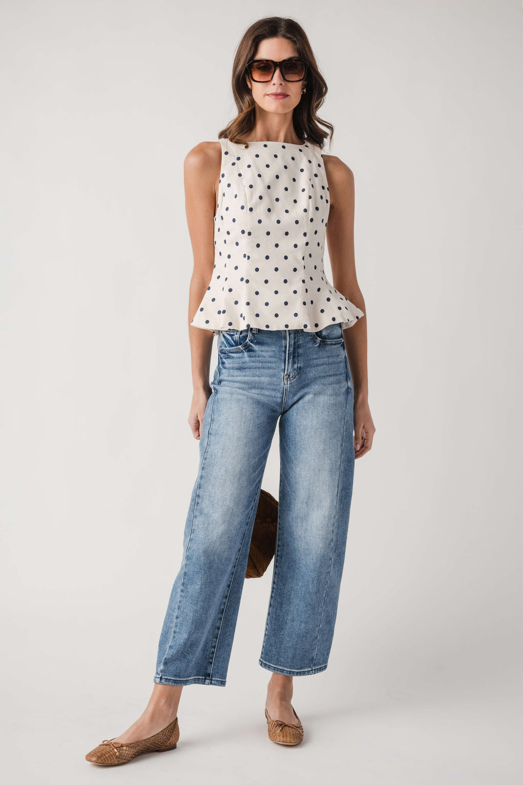 Cream polka dot sleeveless pleated peplum top, front view