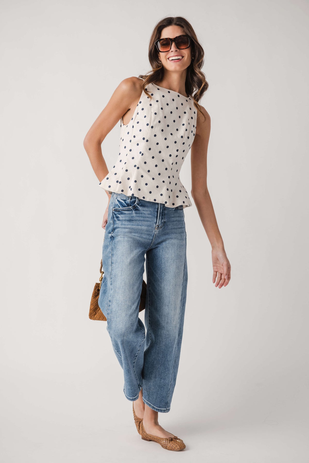 Cream polka dot sleeveless pleated peplum top with round neckline