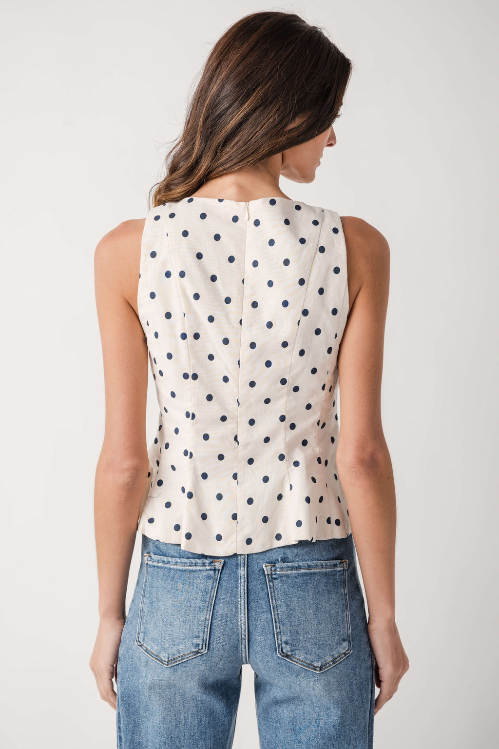 Cream polka dot sleeveless pleated peplum top, back view