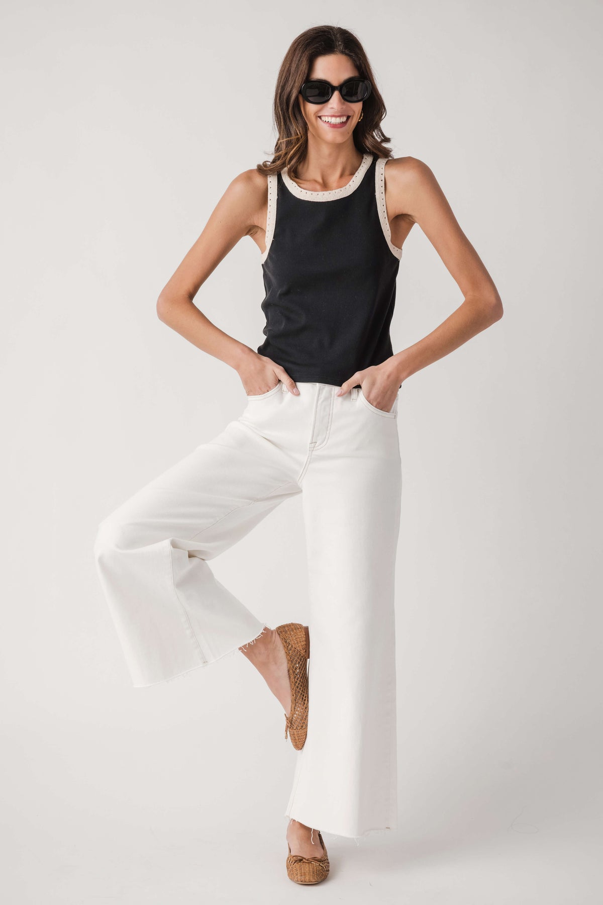 Black ribbed tank with white contrast trim at neckline and armholes, sleeveless.