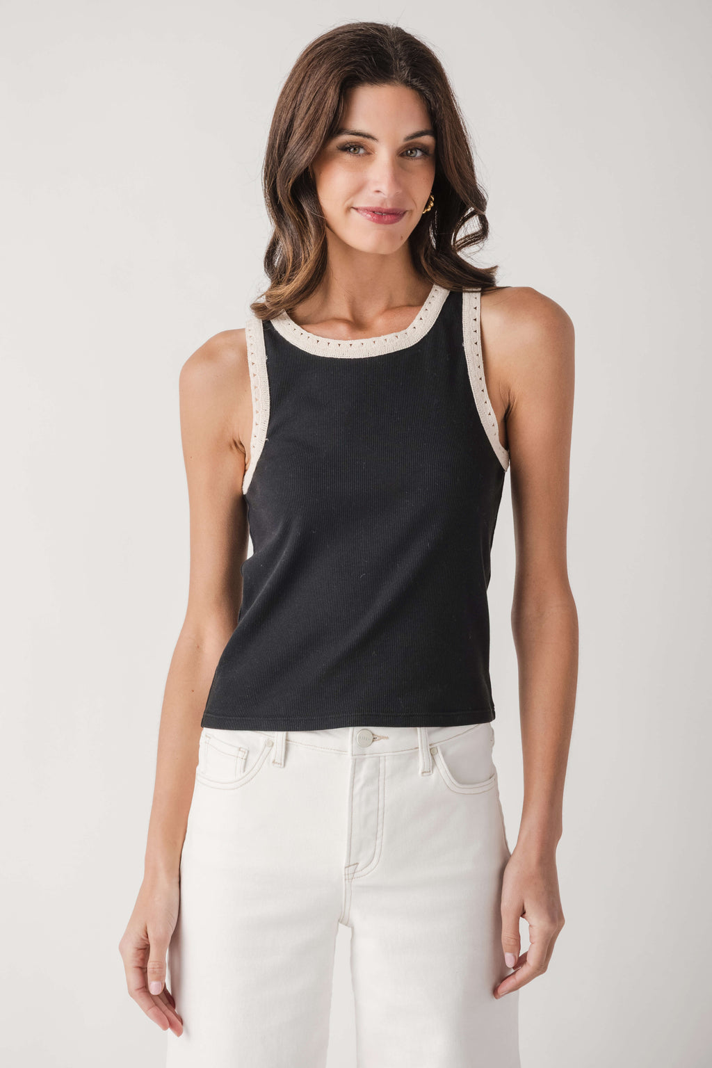 Black ribbed tank top with white contrast neckline and armhole trim, sleeveless.