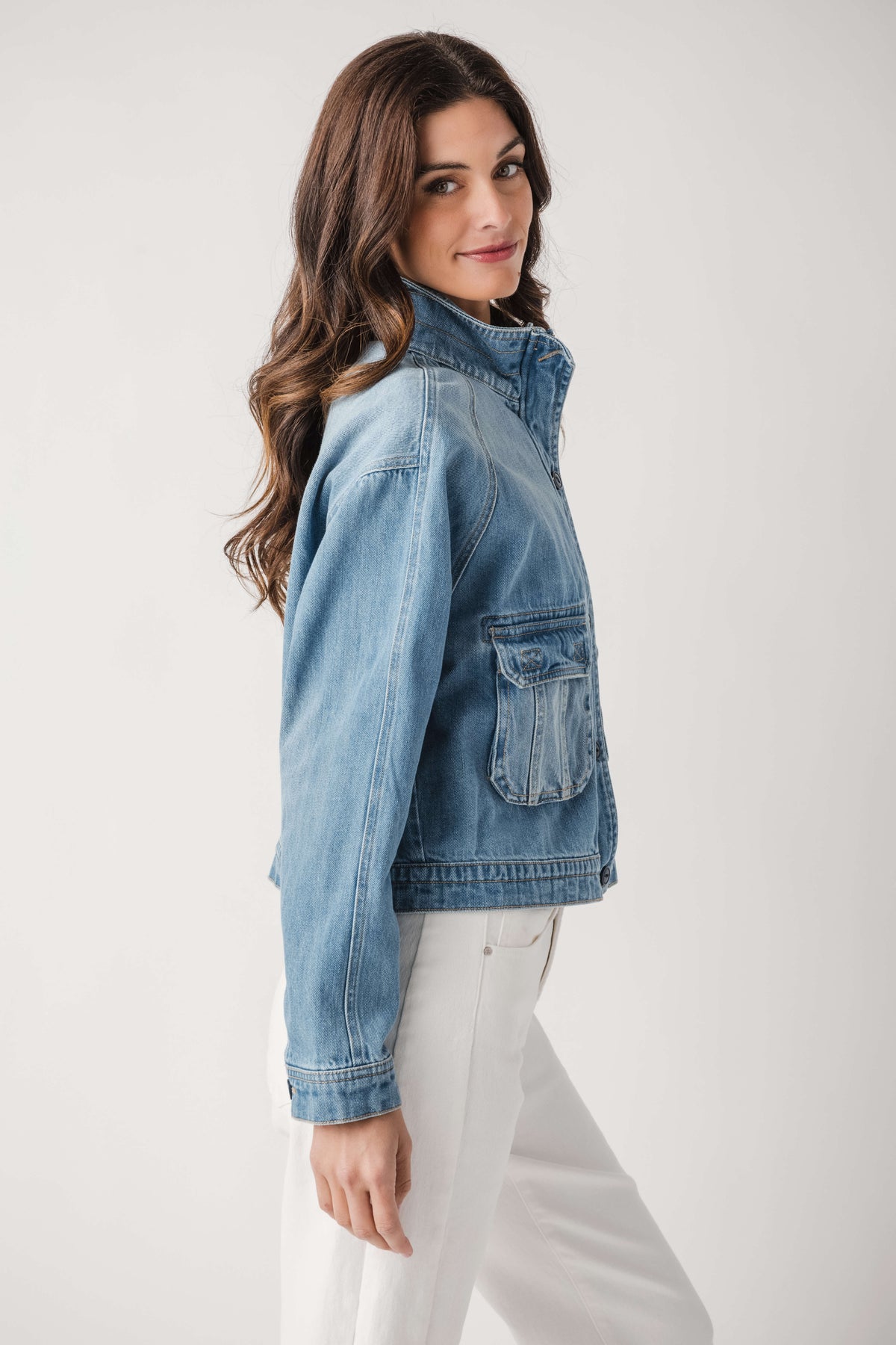Light blue denim jacket side view with flap pocket and buttoned sleeve cuff