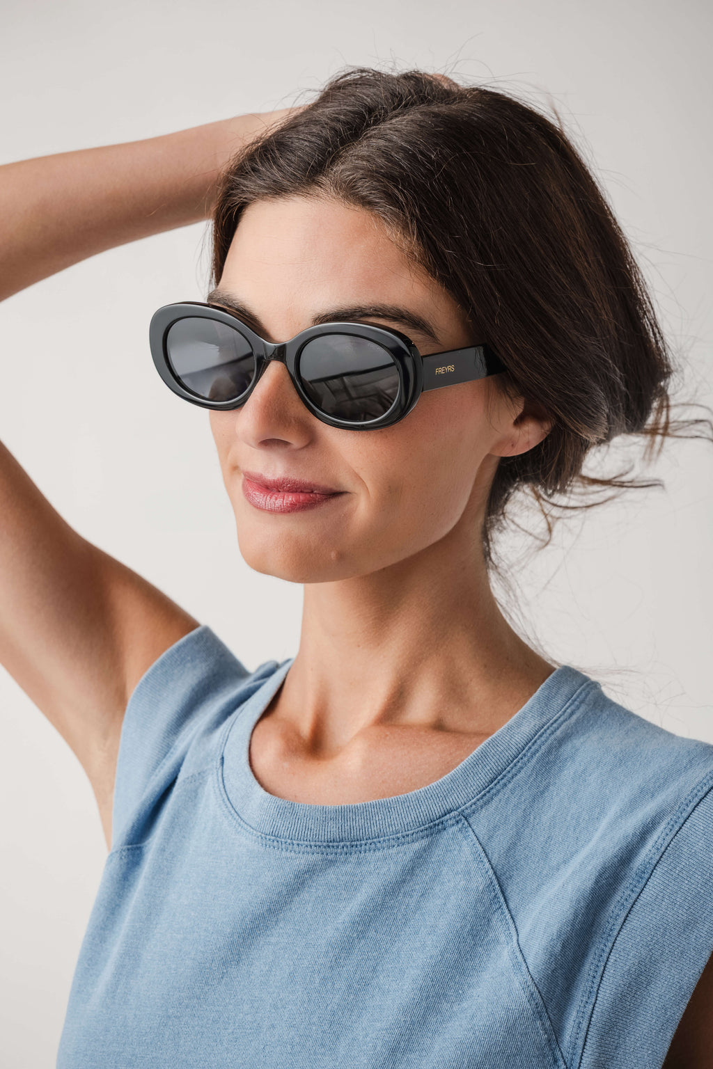 Freyrs Aria black round sunglasses with dark lenses, worn by model side view