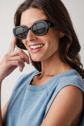 Freyrs Aria black round sunglasses with dark lenses, worn by model angled front view