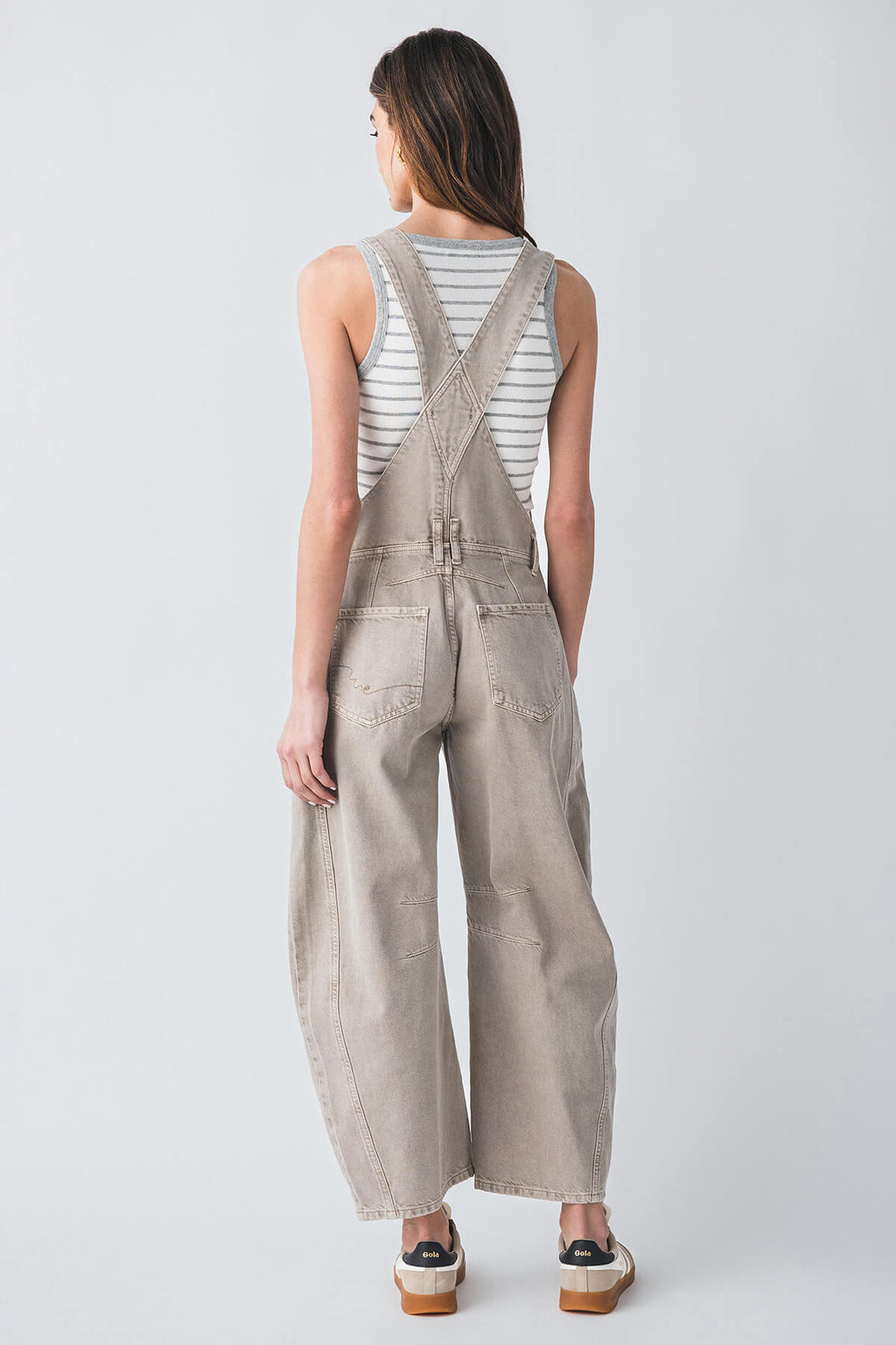 Taupe canvas overalls from back view with cross straps and wide-leg drape.