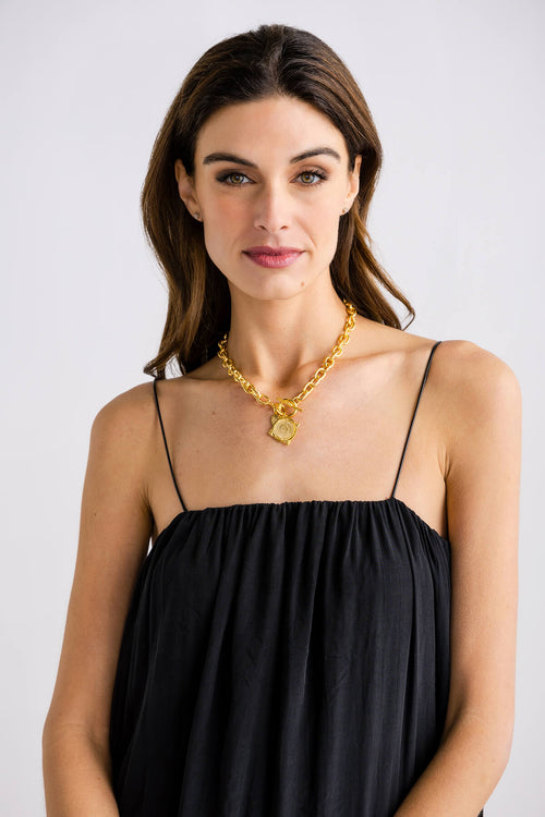 Gold coin pendant toggle necklace with link chain, centered on neckline